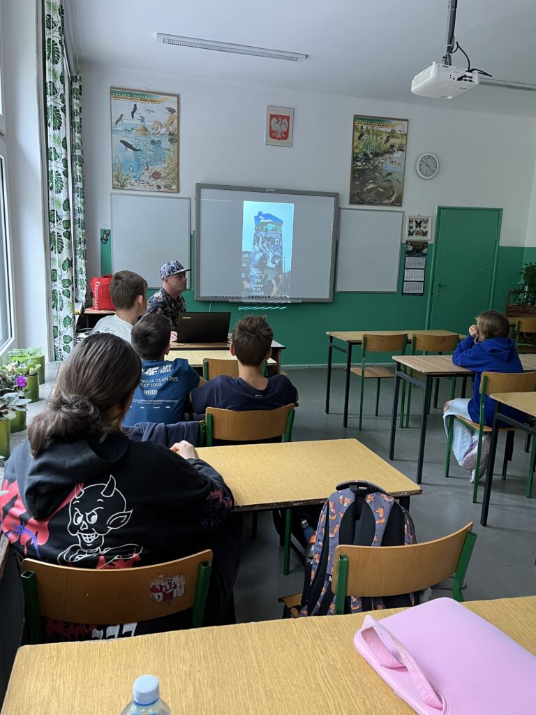 widzimy twórcę muralu prowadzącego warsztaty dla dzieci z naszej szkoły