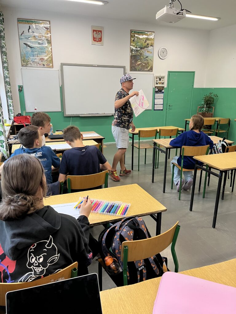 widzimy twórcę muralu prowadzącego warsztaty dla dzieci z naszej szkoły