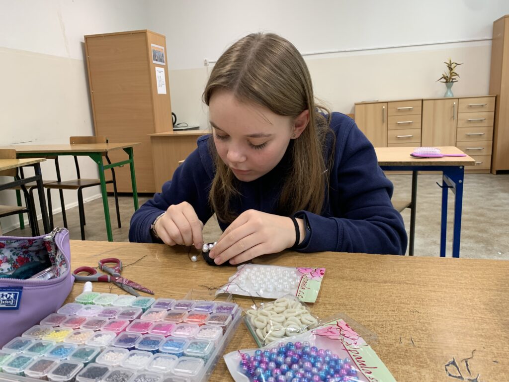 Uczennica siedząca przy ławce robiąca pracę