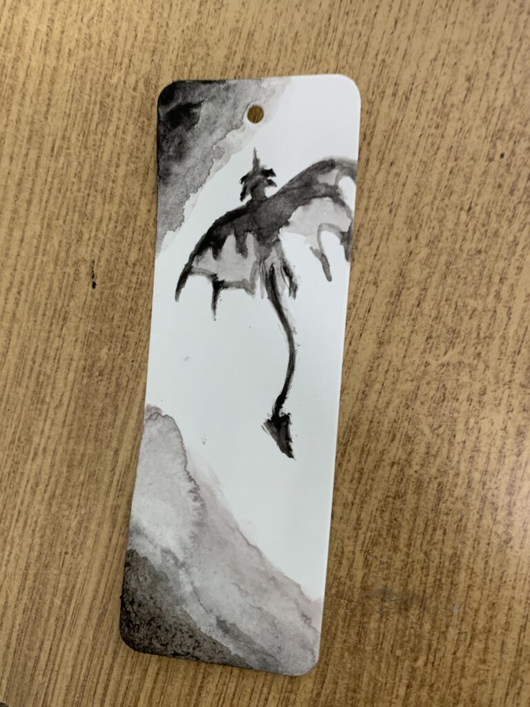 Fotorelacja z zajęć Zakładki do książek - malowane akwarelą, na zdjęciu widać pomalowaną zakładkę do książki