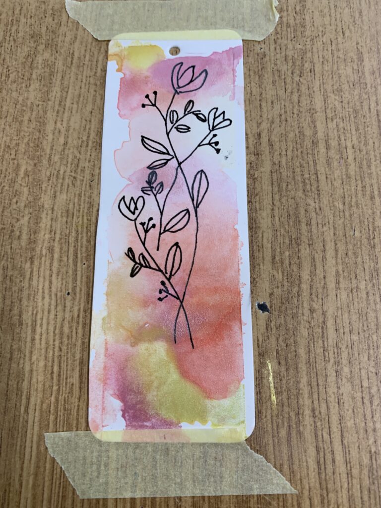 Fotorelacja z zajęć Zakładki do książek - malowane akwarelą, na zdjęciu widać pomalowaną zakładkę do książki