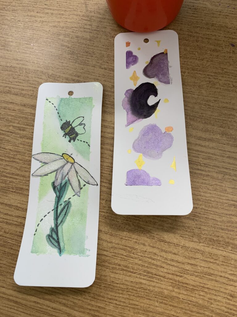 Fotorelacja z zajęć Zakładki do książek - malowane akwarelą, na zdjęciu widać dwie pomalowane zakładki do książek