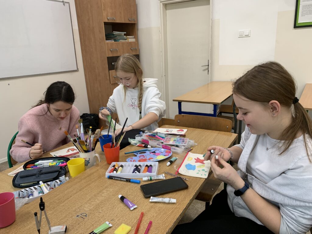 Uczennica siedząca przy ławce robiąca pracę