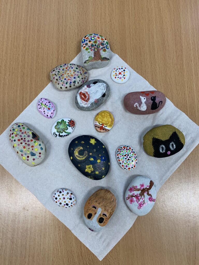 kolorowe pomalowane kamienie leżące na papierze