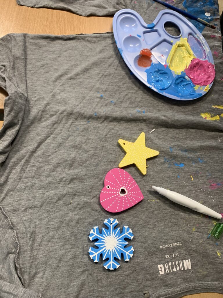 żółta gwiazdka, różowe serduszko oraz niebieska śnieżynka, leżące na szarej szmatce 