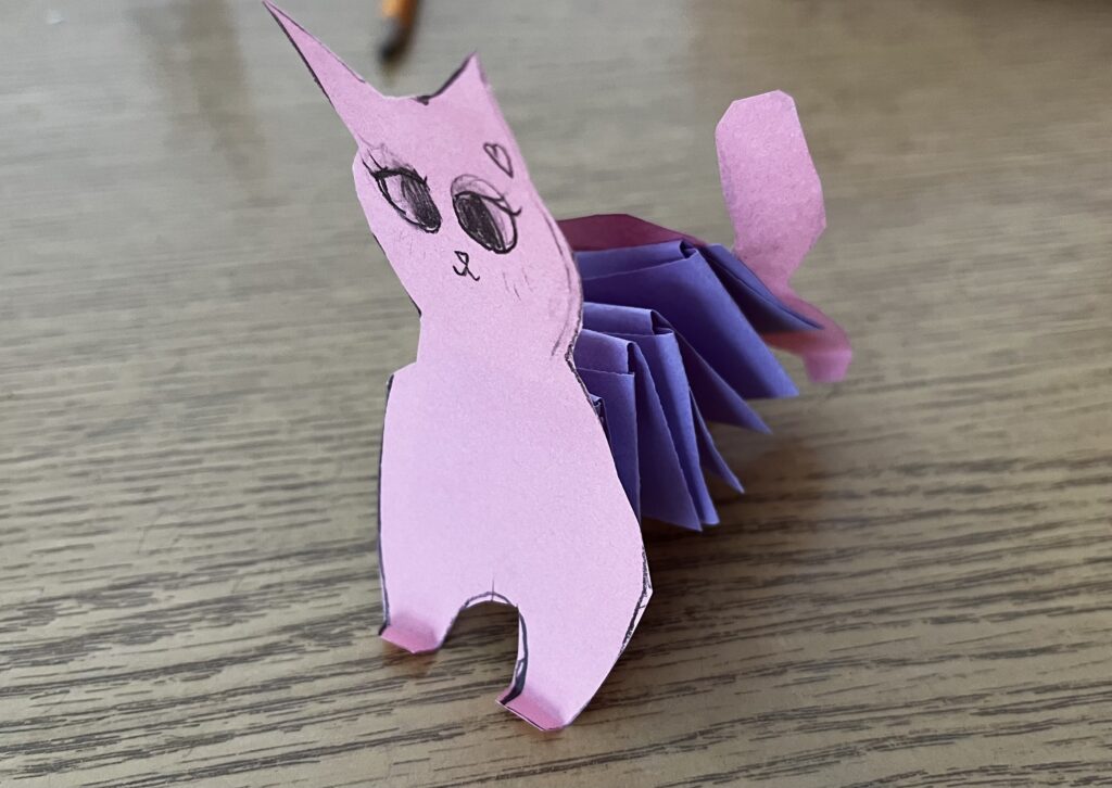 Obrazek przedstawia różowego kota z harmonijką jako tułów.