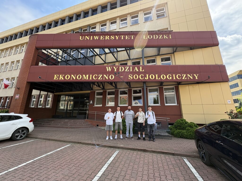 zdjęcie grupowe uczniów z panem Piotrem przed wydziałem